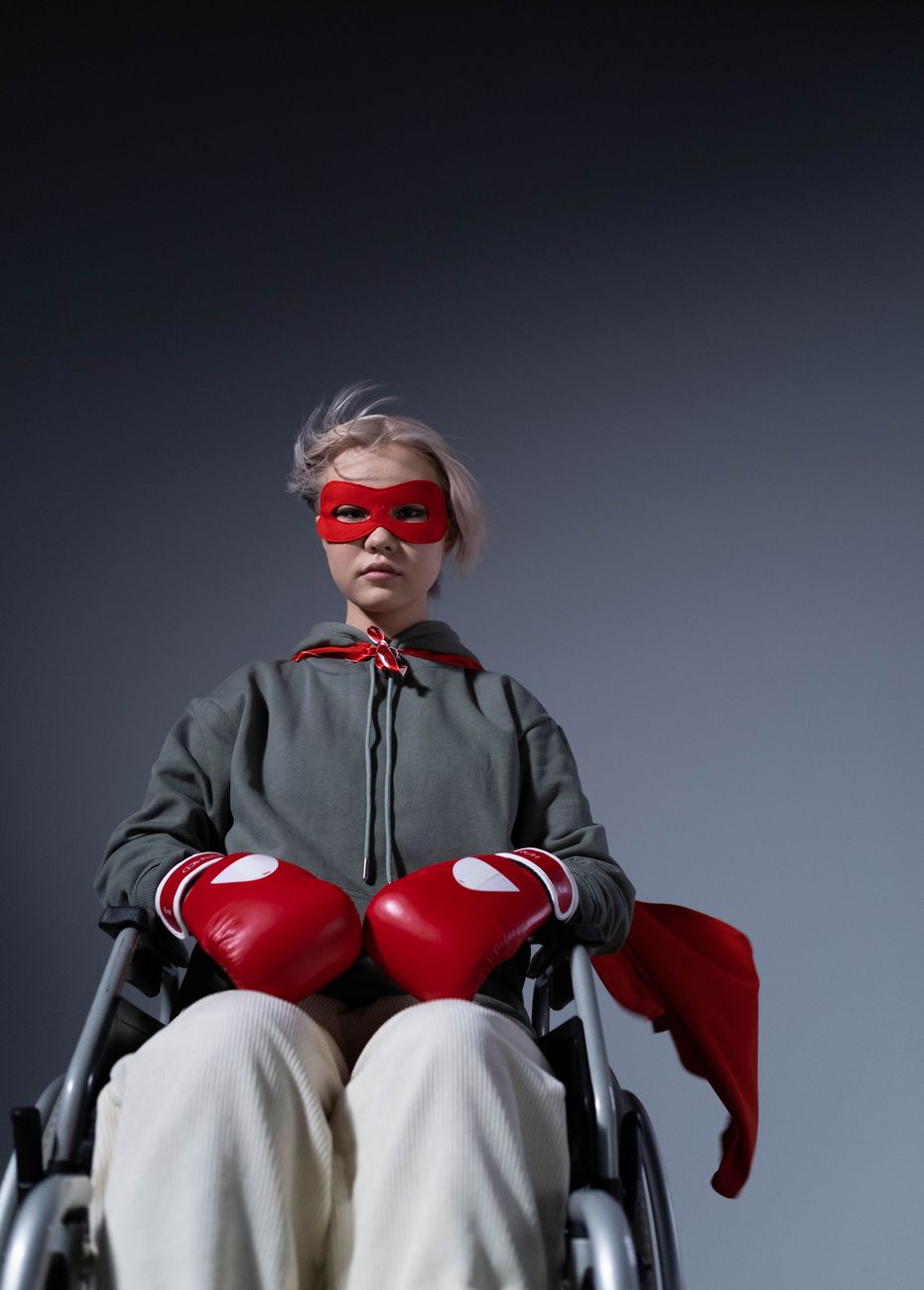 teenage girl wearing boxing gloves sitting on wheelchair