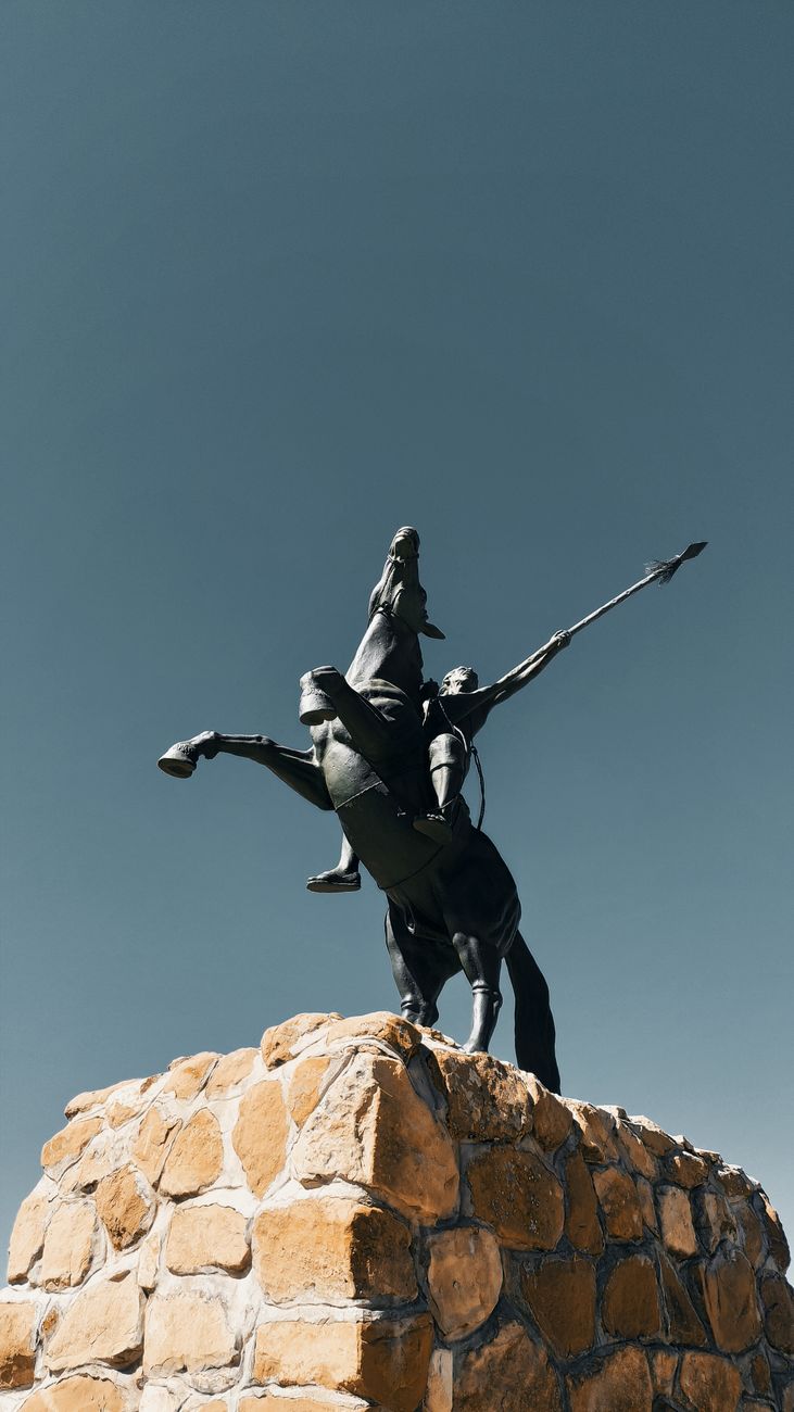 a concrete statue of a man riding a horse